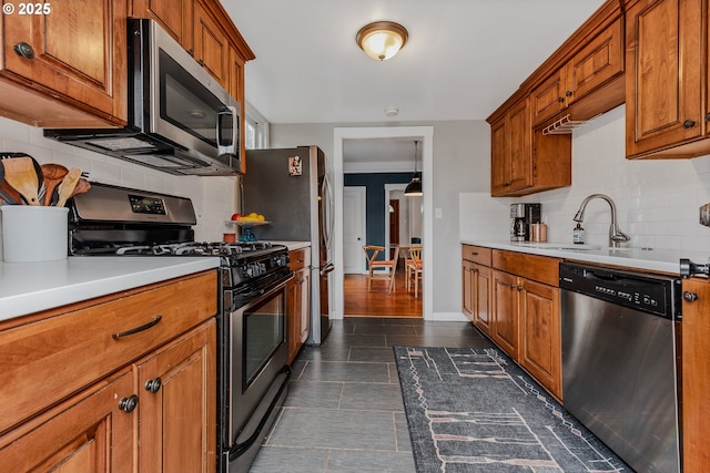 kitchen with tasteful backsplash, appliances with stainless steel finishes, and sink