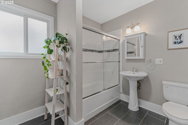 full bathroom with tile patterned flooring, sink, combined bath / shower with glass door, and toilet