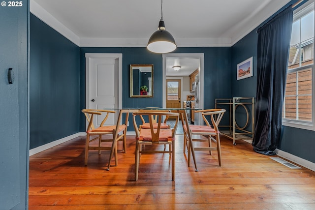 dining room with crown molding and wood-type flooring