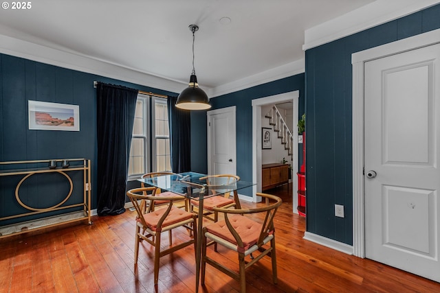 dining space with ornamental molding and hardwood / wood-style floors