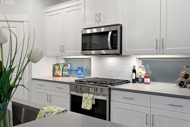 kitchen featuring white cabinets, decorative backsplash, and appliances with stainless steel finishes