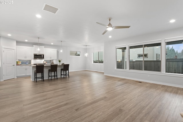 living room with ceiling fan and light wood-type flooring