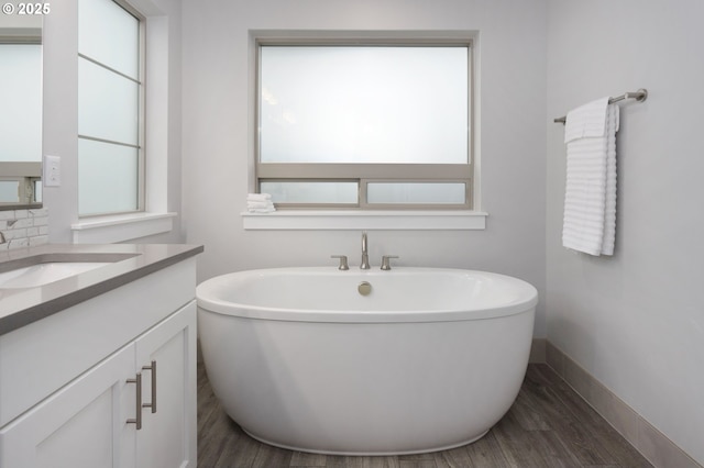 bathroom featuring hardwood / wood-style floors, vanity, and a bath