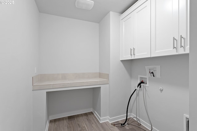 laundry room with hookup for a washing machine, cabinets, and light hardwood / wood-style floors