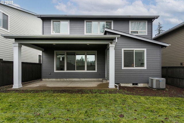 rear view of property with central AC unit, a patio area, and a lawn