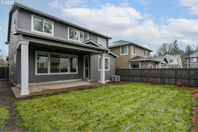 rear view of property with a yard, central AC unit, and a patio area