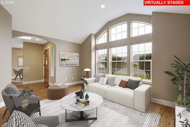 living room with light hardwood / wood-style floors and vaulted ceiling