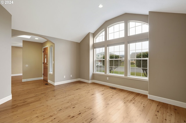 unfurnished room featuring light hardwood / wood-style flooring and vaulted ceiling