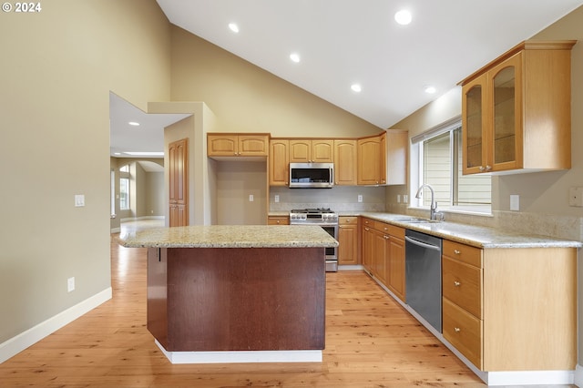 kitchen with a kitchen island, light hardwood / wood-style floors, sink, and appliances with stainless steel finishes