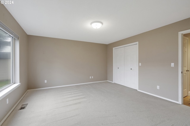 unfurnished bedroom with a closet and carpet floors