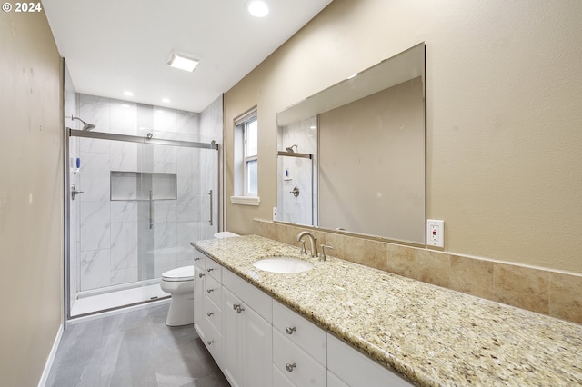 bathroom with vanity, toilet, and a shower with door