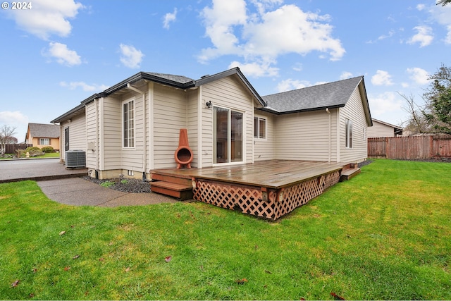 rear view of property featuring a yard, cooling unit, and a deck