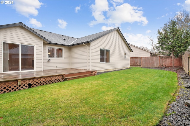 back of house with a wooden deck and a yard