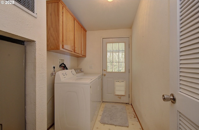 laundry area with separate washer and dryer and cabinets