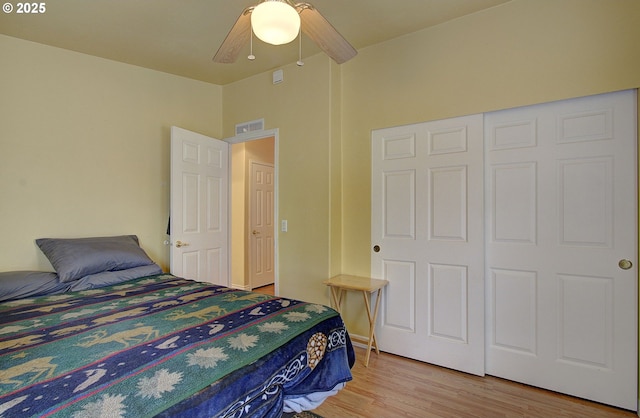 bedroom featuring ceiling fan, light hardwood / wood-style flooring, and a closet