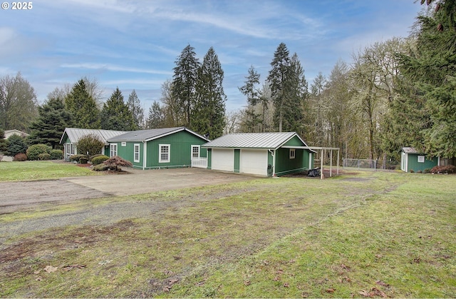 view of front of home with a garage, a shed, and a front lawn