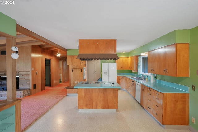 kitchen featuring a center island, white appliances, wooden walls, a fireplace, and beamed ceiling