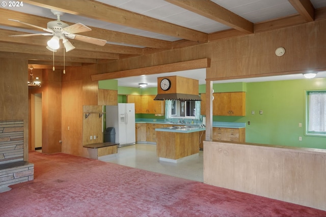 kitchen featuring beam ceiling, island exhaust hood, ceiling fan, and white refrigerator with ice dispenser