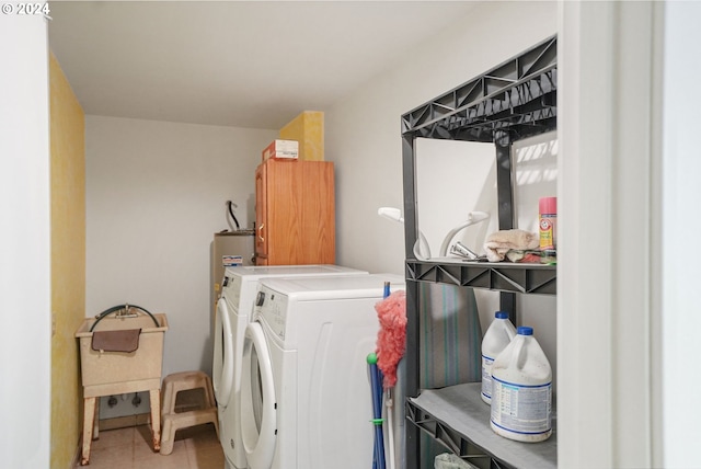 laundry area featuring tile patterned flooring, washing machine and dryer, and cabinets