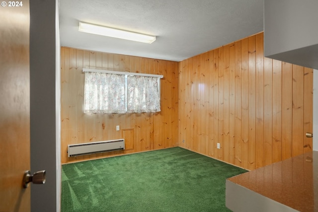 carpeted spare room with baseboard heating and wooden walls