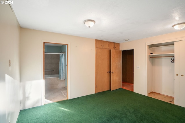 unfurnished bedroom featuring carpet and ensuite bath