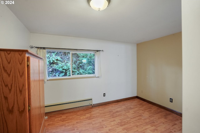 empty room featuring light hardwood / wood-style flooring and a baseboard heating unit