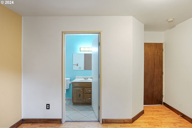 corridor featuring light hardwood / wood-style flooring and sink