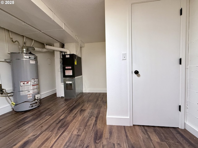 utility room featuring heating unit and strapped water heater