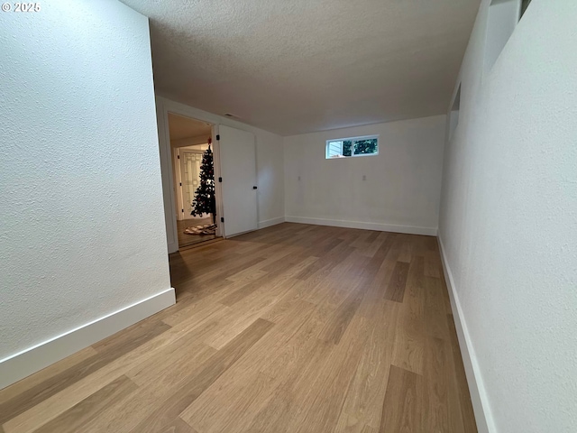 empty room featuring a textured ceiling and light wood-type flooring