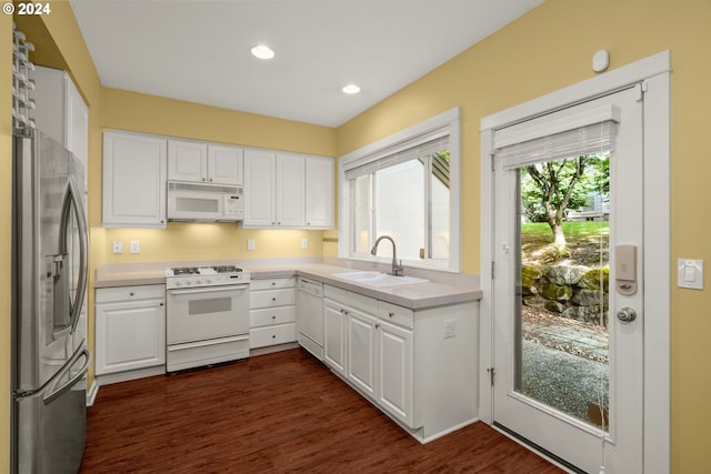 kitchen with white cabinets, dark hardwood / wood-style flooring, white appliances, and sink