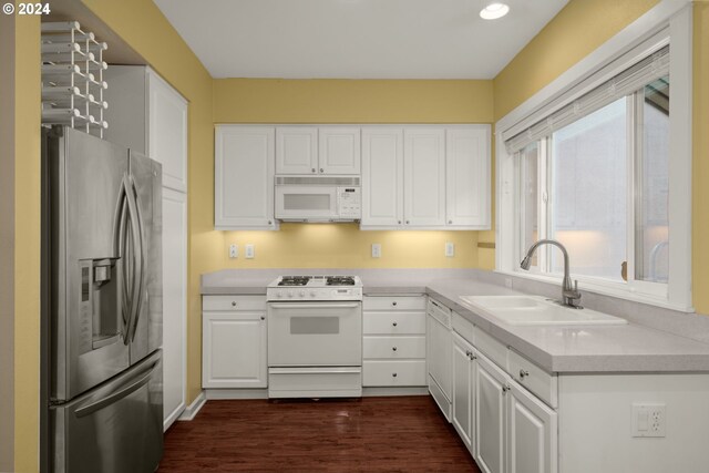 kitchen featuring white cabinetry, dark hardwood / wood-style flooring, white appliances, and sink