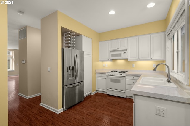 kitchen with white cabinets, dark hardwood / wood-style floors, white appliances, and sink