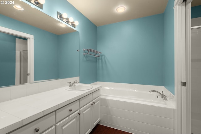 bathroom with hardwood / wood-style flooring, vanity, and separate shower and tub