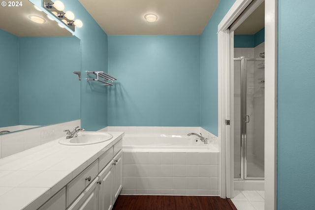 bathroom with vanity, wood-type flooring, and shower with separate bathtub