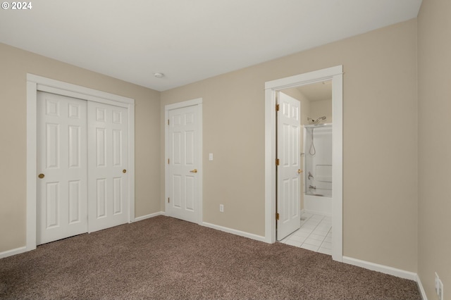 unfurnished bedroom featuring connected bathroom, a closet, and light colored carpet