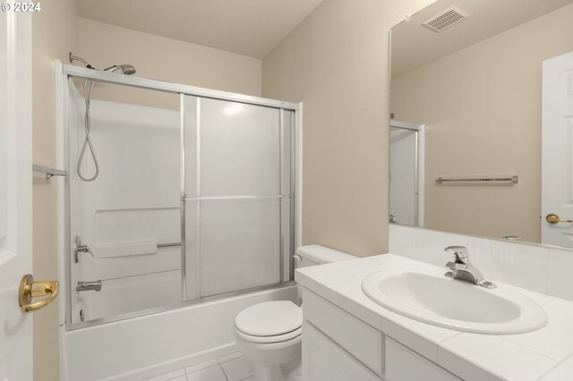 full bathroom with tile patterned floors, vanity, toilet, and enclosed tub / shower combo