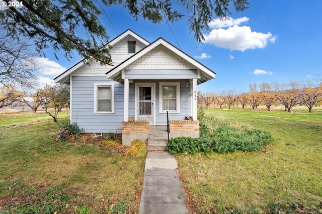 bungalow-style house featuring a porch and a front lawn