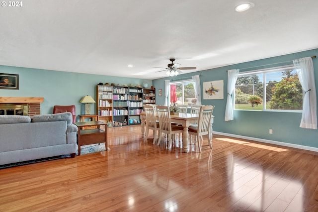 dining space with ceiling fan and light wood-type flooring