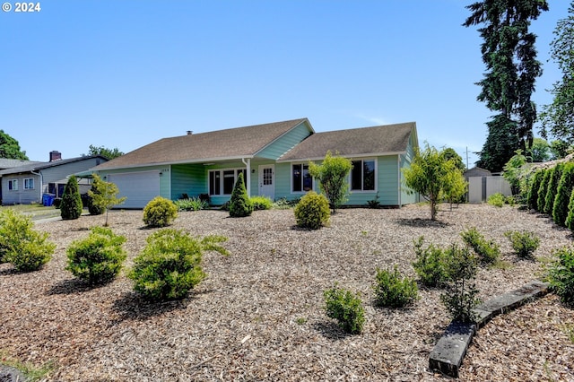 ranch-style house featuring a garage and a storage shed