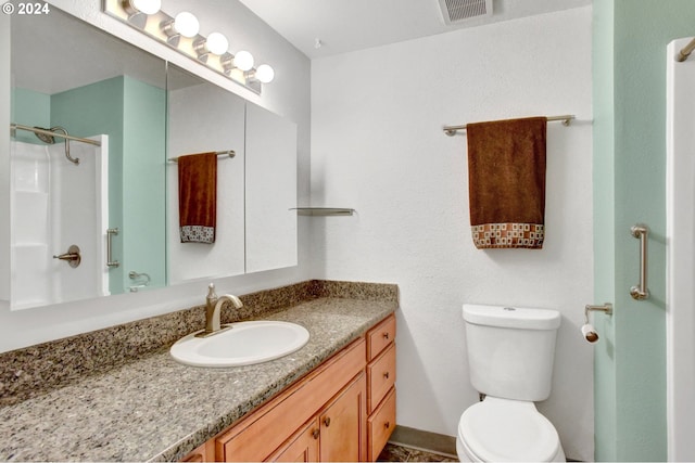 bathroom with vanity, toilet, and walk in shower