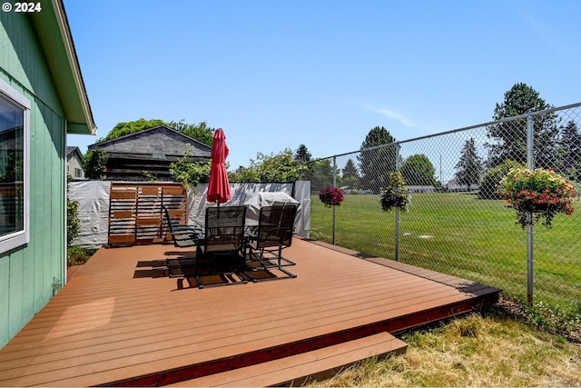 wooden deck featuring a lawn