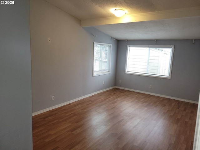 empty room featuring wood-type flooring and a textured ceiling