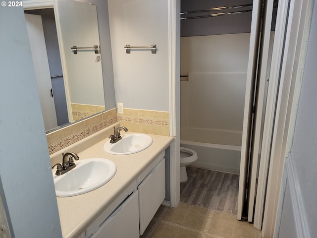 bathroom featuring vanity, backsplash, and toilet