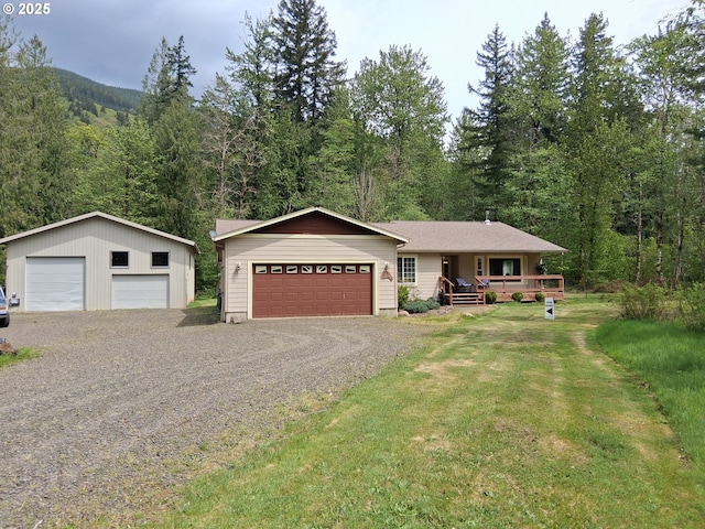 ranch-style home with a garage, a view of trees, a porch, and a front yard