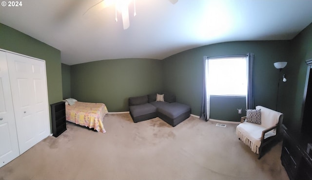 bedroom featuring a closet, light colored carpet, and vaulted ceiling