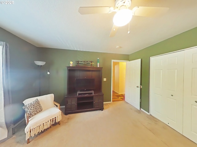 living area featuring carpet floors, a ceiling fan, and baseboards