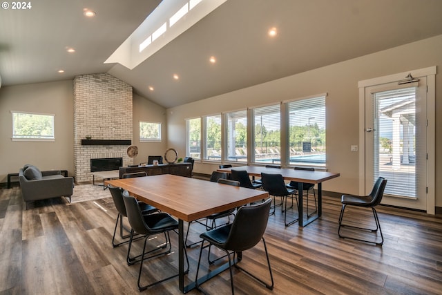 dining space featuring a fireplace, high vaulted ceiling, and dark hardwood / wood-style floors