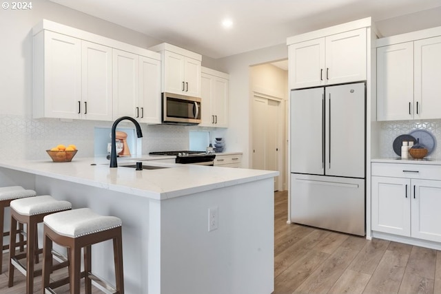 kitchen with white cabinetry, a breakfast bar, and stainless steel appliances