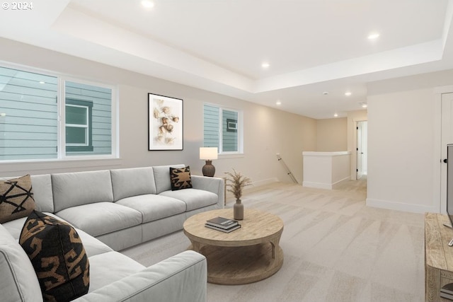 bedroom with light carpet and a tray ceiling