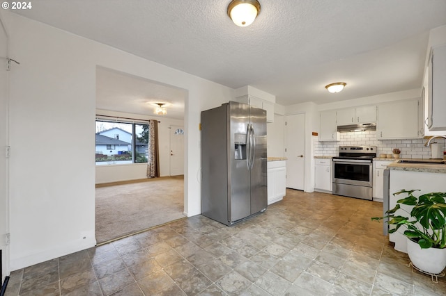 kitchen with sink, white cabinets, decorative backsplash, stainless steel appliances, and light carpet